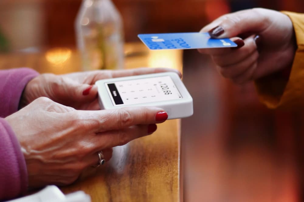 Hóspede pagando a diária com cartão na recepção